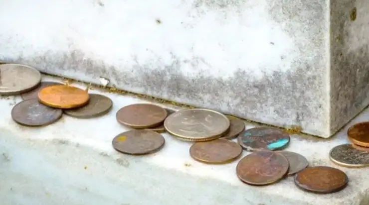 Pourquoi les gens laissent-ils des pièces sur les tombes : sens et signification